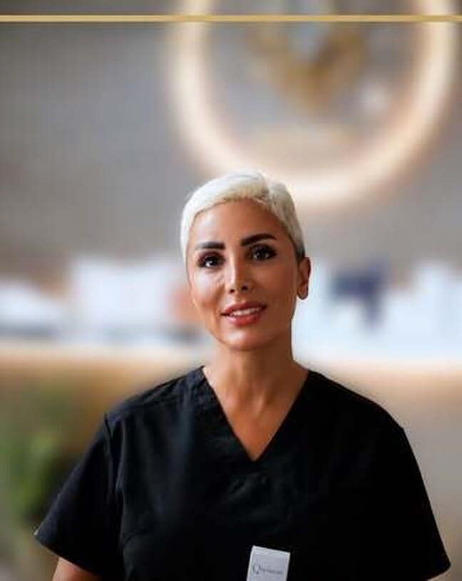 A Muchin Beauty Clinic practitioner holding a skincare product in the clinic